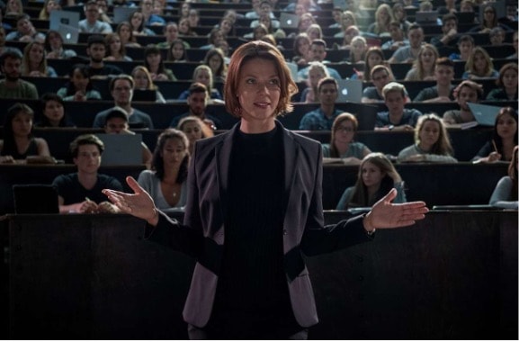 Abb. 2: Geschafft! Mia/Emma (Luna Wedler, Hintergrund rechts)) hat mit ihren bahnbrechenden Leistungen überzeugt und ist in den Mitarbeiterstab von Professorin Dr. Tanja Lorenz (Jessica Schwarz) aufgenommen wurden. © Netflix