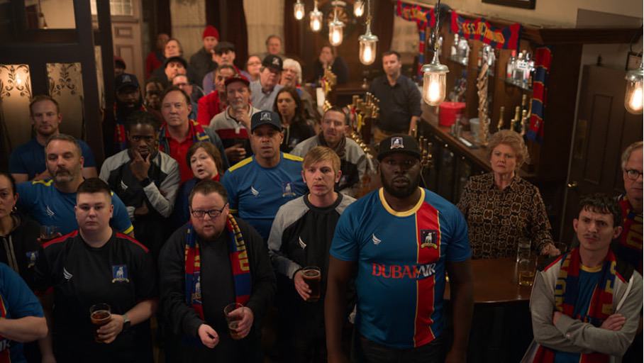 Abb. 6: Die Anhänger des AFC Richmond verfolgen gebannt in dem Pub der Richmond-Anhängerin und guten Seele Mae (Annette Badland, hinter der Theke), wie das Spiel gegen Manchester City ausgeht.